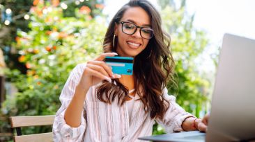 Young-woman-sitting-at-cafe-making-online-shopping-2023-11-27-05-36-46-utc